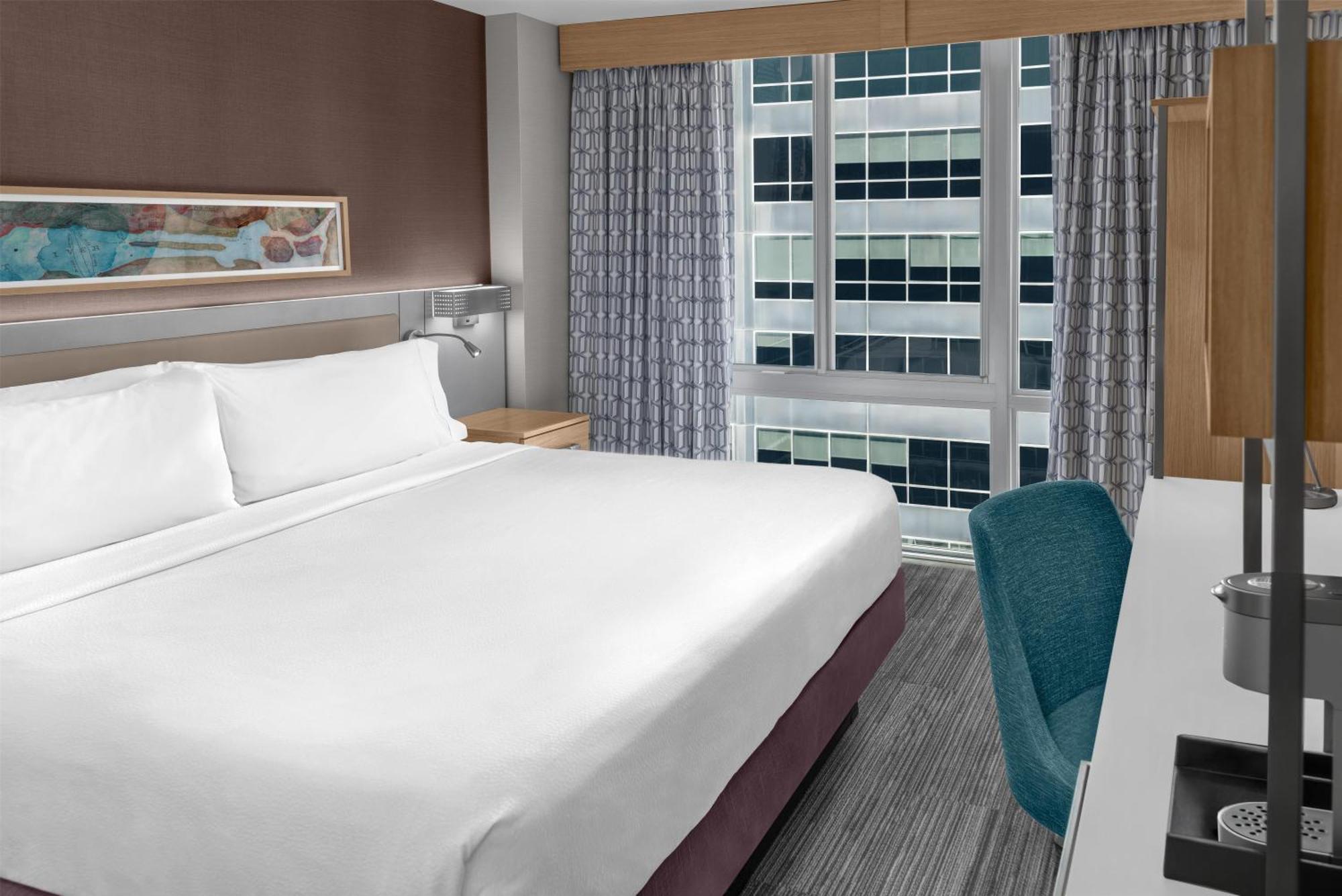 Zimmer mit Kingsize-Bett und raumhohem Fenster